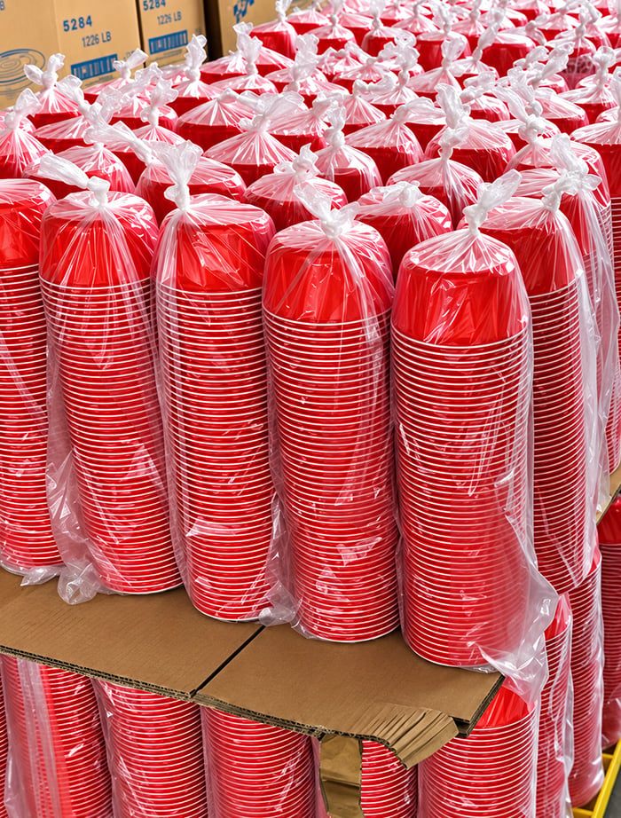 Stacked red disposable food bowls in warehouse