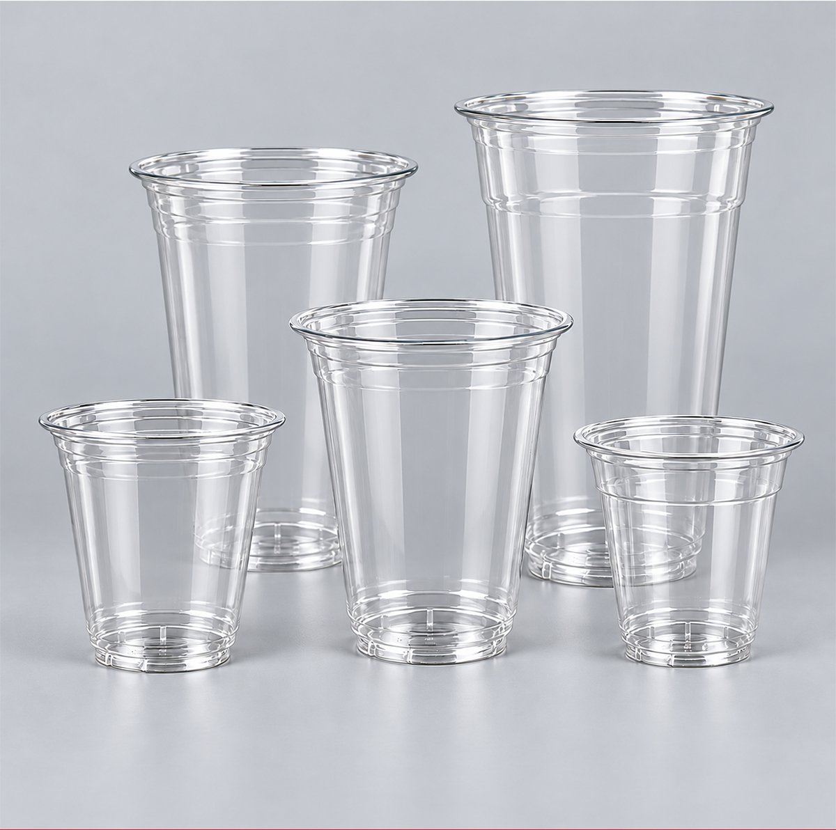 Five clear disposable PET cups in assorted sizes