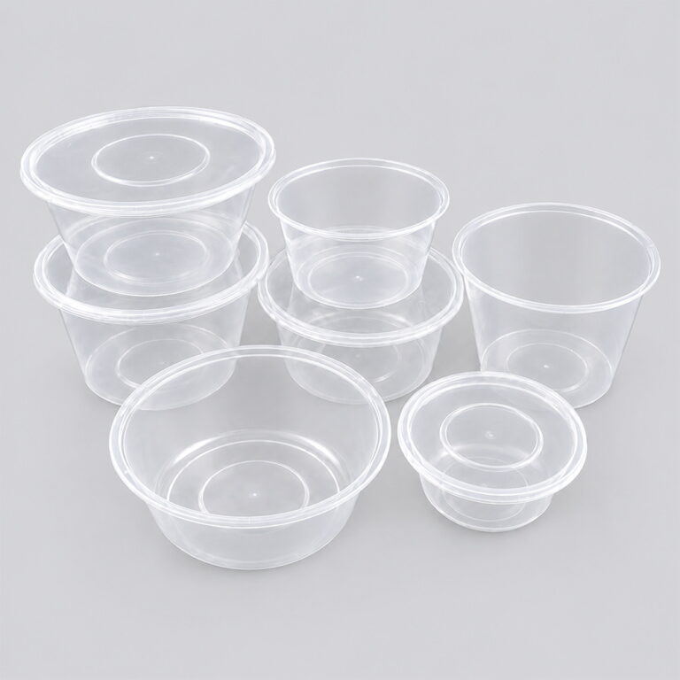 Assorted clear round PP food containers with lids on grey background