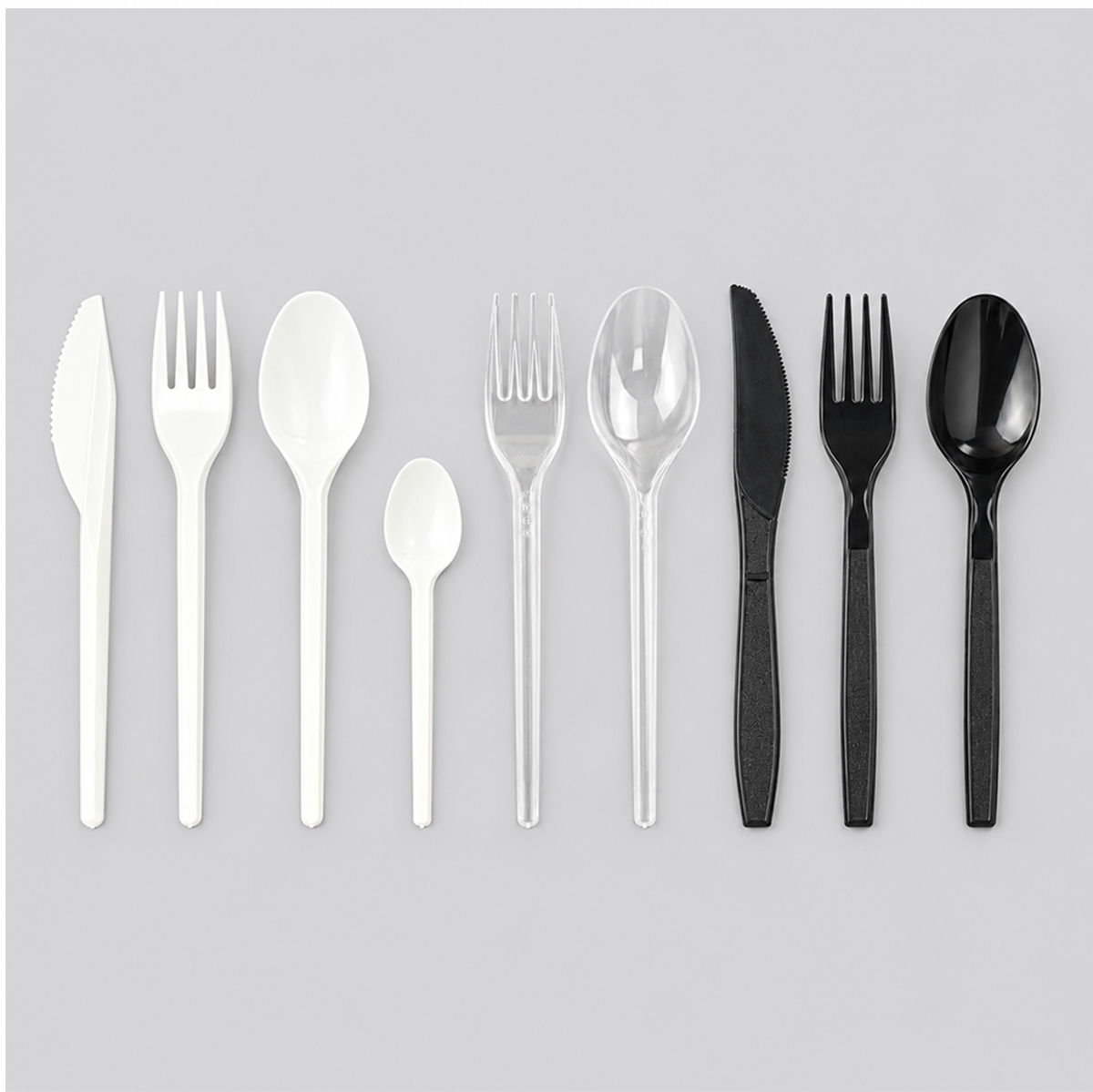 Range of white, clear and black disposable cutlery lined up